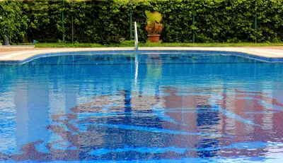 a swimming pool with a reflection in the water at Hotel Caribe in Rota