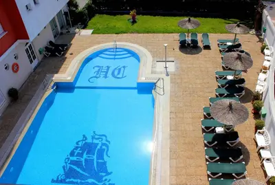 an overhead view of a large swimming pool with umbrellas at Hotel Caribe in Rota