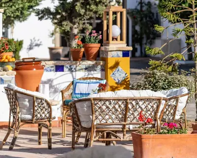 a patio with chairs and tables and potted plants at Puerta de Algadir in El Puerto de Santa María
