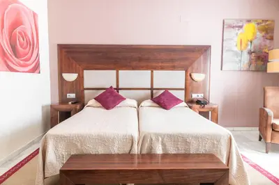 a bedroom with a large bed with purple pillows at Puerta de Algadir in El Puerto de Santa María