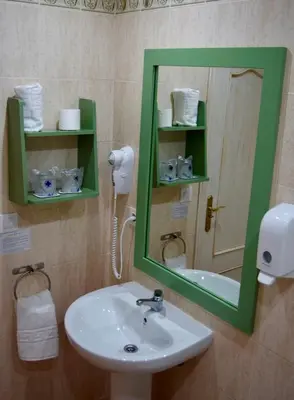 a bathroom with a sink and a mirror at Puerta de Algadir in El Puerto de Santa María