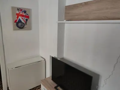 a living room with a flat screen tv and a wall at Estudio Alicia in Rota
