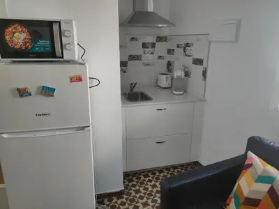 a small kitchen with a refrigerator and a microwave at Estudio Alicia in Rota
