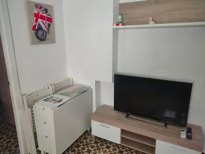 a living room with a flat screen tv and a refrigerator at Estudio Alicia in Rota