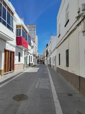 an empty street in a city with white buildings at Estudio Alicia in Rota