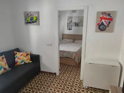 a small bedroom with a bed and a couch at Estudio Alicia in Rota