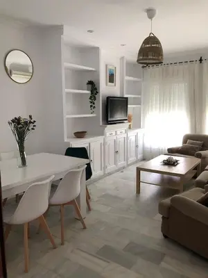 a white living room with a table and a couch at VILLA SALMONETE in Sanlúcar de Barrameda