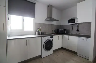 a white kitchen with a washing machine in it at Apartamento Herrería centro in El Puerto de Santa María