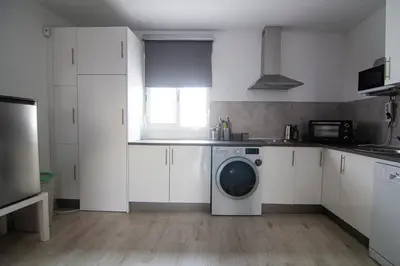 a white kitchen with a washing machine in it at Apartamento Herrería centro in El Puerto de Santa María