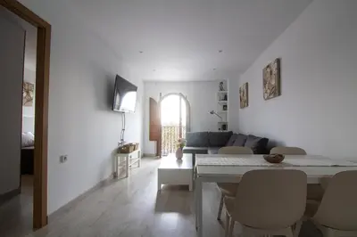 a white living room with a table and a couch at Apartamento Herrería centro in El Puerto de Santa María