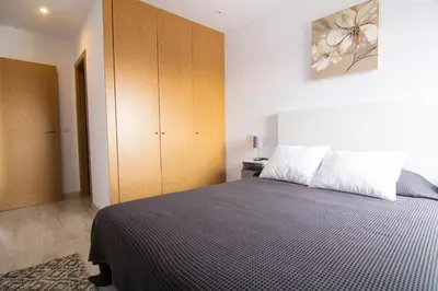 a bedroom with a black and white bed and a cabinet at Apartamento Herrería centro in El Puerto de Santa María