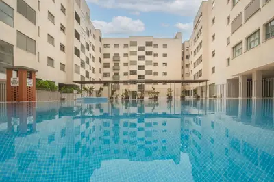 a swimming pool in front of two buildings at Apartamento céntrico con piscina, temporada in El Puerto de Santa María