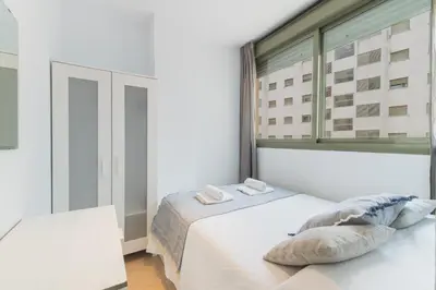 a bedroom with a bed and a large window at Apartamento céntrico con piscina, temporada in El Puerto de Santa María