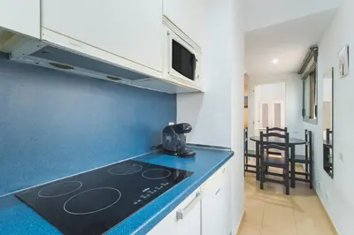 a kitchen with a stove and a blue counter top at Apartamento céntrico con piscina, temporada in El Puerto de Santa María