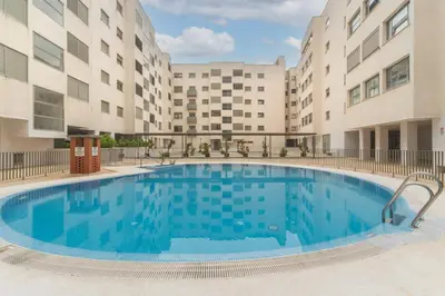 a large pool in the courtyard of a apartment building at Apartamento céntrico con piscina, temporada in El Puerto de Santa María