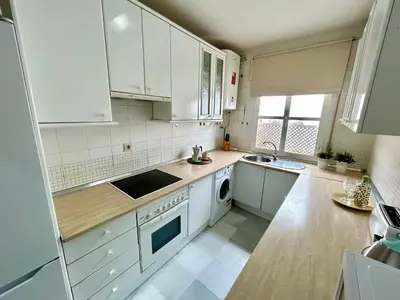a kitchen with white cabinets and a sink and a dishwasher at GATU Guateque , 