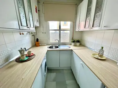 a small kitchen with white cabinets and a sink at GATU Guateque , 
