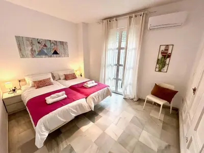 a white bedroom with a large bed and a chair at GATU Guateque , 