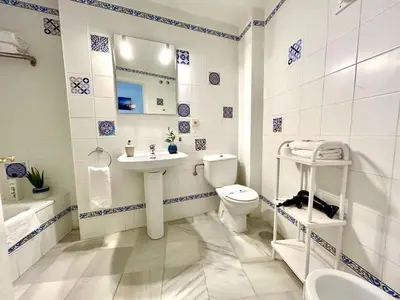 a bathroom with a toilet and a sink and a mirror at GATU Guateque , 