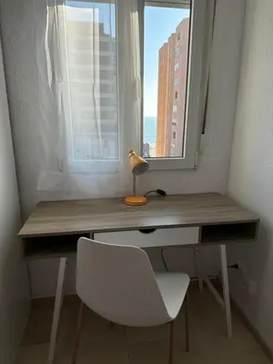 a desk with a white chair and a window at Apartamento Vista-Beach in Cádiz