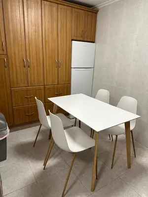 a kitchen with a white table and chairs and a refrigerator at Apartamento Vista-Beach in Cádiz