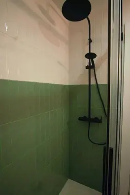 a bathroom with a shower with green tiles at Ocean View Ha Apartment in Cádiz