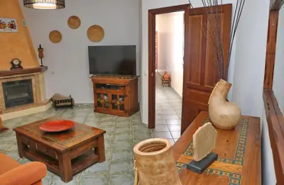 a living room with a television and a table at Casa de los Abuelos in Hozanejos