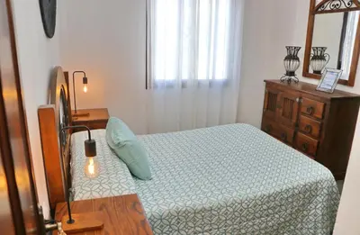 a small bedroom with a bed and a dresser at Casa de los Abuelos in Hozanejos