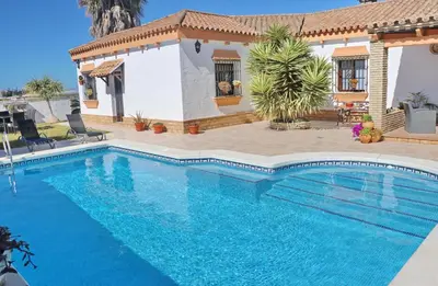 a swimming pool in front of a house at Casa de los Abuelos in Hozanejos