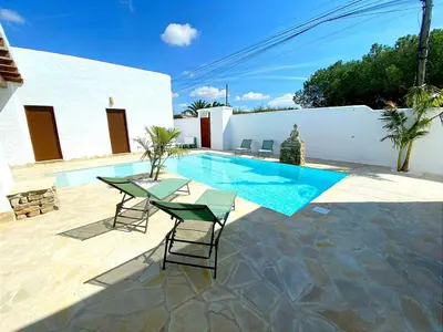 a swimming pool with a table and chairs next to a house at GALDANA in Chiclana de la Frontera