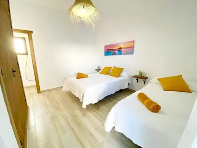 a bedroom with two beds and a chandelier at GALDANA in Chiclana de la Frontera