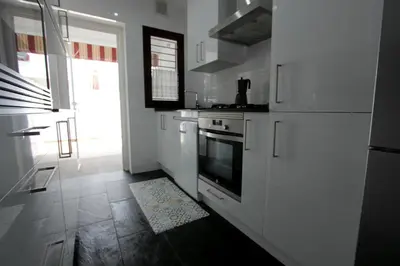 a kitchen with white cabinets and a stove top oven at ConiL Casa H&L in Conil de la Frontera