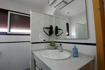 a bathroom with a sink and a mirror at ConiL Casa H&L in Conil de la Frontera