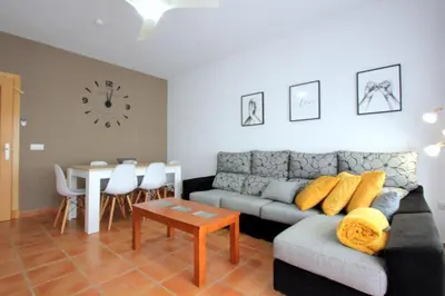 a living room with a couch and a table and a clock at ConiL Casa H&L in Conil de la Frontera