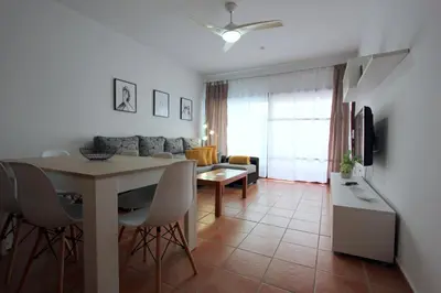 a kitchen and living room with a table and a couch at ConiL Casa H&L in Conil de la Frontera