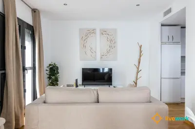 a living room with a couch and a tv at Estrella del Mar- FREE PARKING by LiveWork in Cádiz
