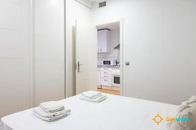a white kitchen with a table with towels on it at Estrella del Mar- FREE PARKING by LiveWork in Cádiz