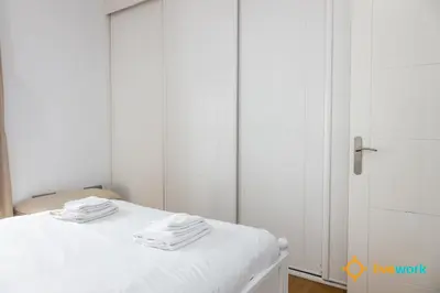 a bedroom with a white bed with a closet at Estrella del Mar- FREE PARKING by LiveWork in Cádiz
