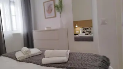 a bedroom with towels on a bed with a mirror at Apartamento Poniente Sanlúcar - Centro in Sanlúcar de Barrameda