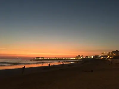 a group of people on the beach at sunset at Hotel Spa Cádiz Plaza in Cádiz