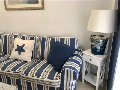 a blue and white striped couch sitting next to a lamp at Apartamento DUPLEX CRUZ DEL MAR in Chipiona