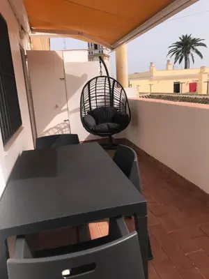 a black table and chairs on a balcony at Apartamento DUPLEX CRUZ DEL MAR in Chipiona