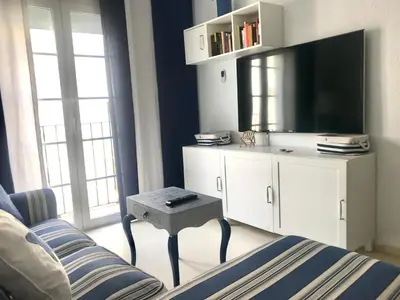 a living room with a couch and a tv at Apartamento DUPLEX CRUZ DEL MAR in Chipiona