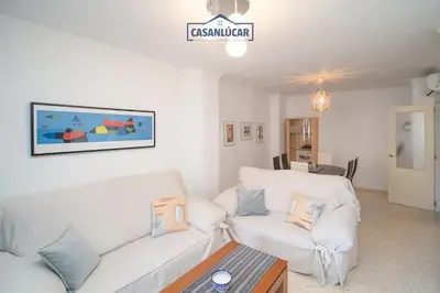 a living room with two white couches and a tv at Apartamento Cigüeña in Sanlúcar de Barrameda