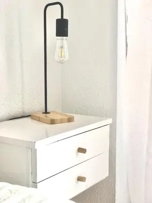 a bedside table with a lamp on top of it at Frente al mar, preciosas vistas, piscinas , valdelagrana in El Puerto de Santa María