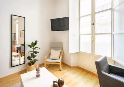 a living room with a couch and a chair at Apartamento luminoso y céntrico in Cádiz