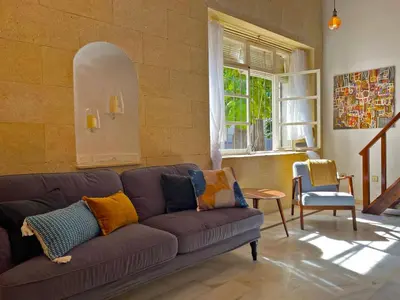 a living room with a purple couch and a window at Apartamento Intramuros - Ole Solutions in Jerez de la Frontera