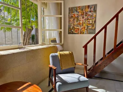 a living room with a chair and a window at Apartamento Intramuros - Ole Solutions in Jerez de la Frontera