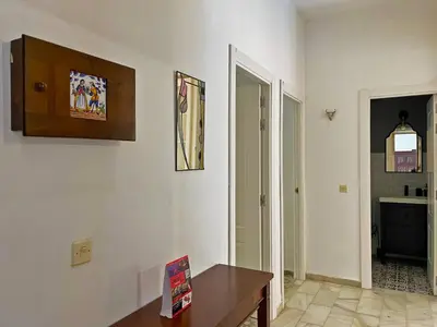 a living room with a table and a hallway at Apartamento Intramuros - Ole Solutions in Jerez de la Frontera