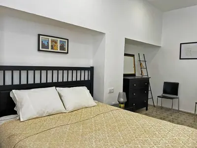 a bedroom with a bed and a dresser and a chair at Apartamento Intramuros - Ole Solutions in Jerez de la Frontera